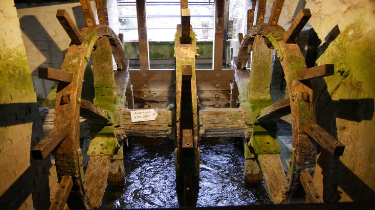Old mill wheel with paddles removed, in a state of disrepair